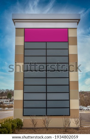 Tall decorative strip mall pylon, monument, advertisement billboard sign with no logos with enough space for 20 stores blue cloudy background