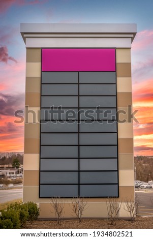 Tall decorative strip mall pylon, monument, advertisement billboard sign with no logos with enough pink and gray panel space for 20 stores colorful orange sunset background