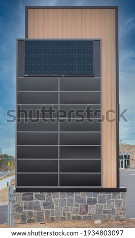 Tall decorative strip mall pylon, monument, advertisement billboard sign with no logos with enough brown panel space for 16 stores blue sky background, electric display wood panel