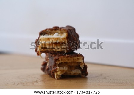 The chocolate bar is split in half on a wood table. white background