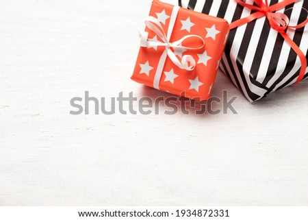 Composition of Gifts wrapped in bright colorful paper on white wooden background. Background for Christmas, New year, birthday or any other celebration.