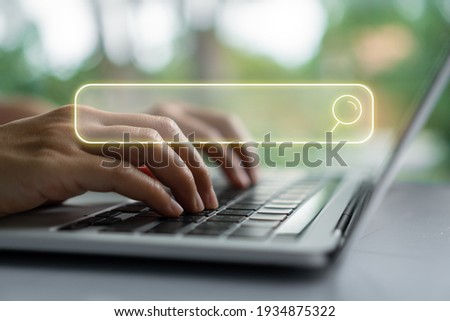 People hand using laptop or computor searching for information in internet online society web with search box icon and copyspace. Royalty-Free Stock Photo #1934875322
