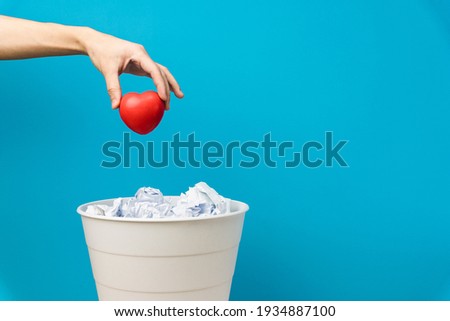 The heart is thrown into the trash can. Lovers are not appreciated and thrown away Royalty-Free Stock Photo #1934887100