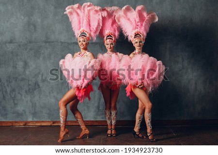 Three Women in cabaret costume with pink feathers plumage Royalty-Free Stock Photo #1934923730