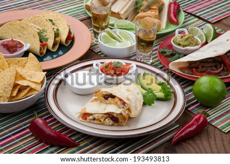 Assorted Mexican dishes, with chicken quesadilla as the main subject. 