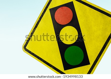 
Sign with traffic light on sky background