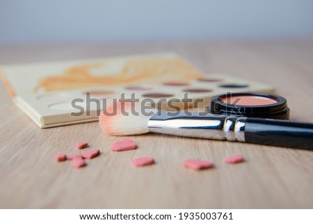 Palette of colorful eye shadows. Pink background.