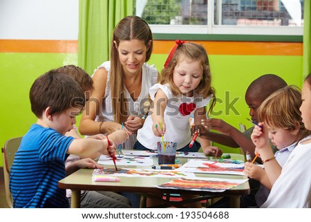 Many children painting together with nursery teacher in a kindergarten Royalty-Free Stock Photo #193504688