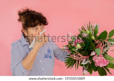 woman bouquet flowers hands take hankie sneezes closed eyes concept allergy illness discomfort pink background