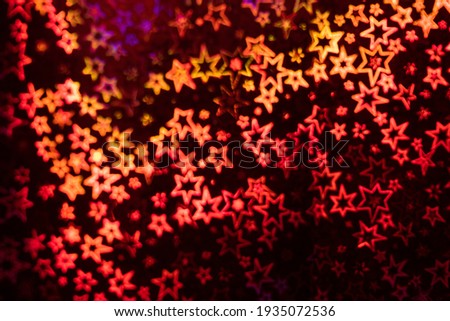 Red stars shimmer in different shades, starry bokeh, background. Abstraction.