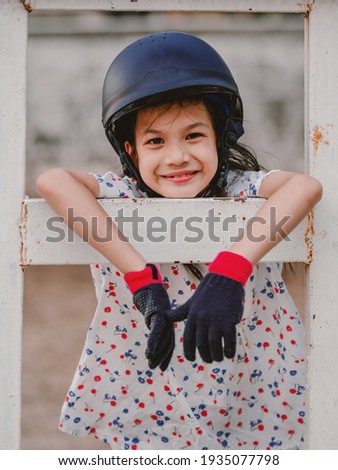 Asian school kid girl with horse, riding or practicing horse riding at the horse ranch.