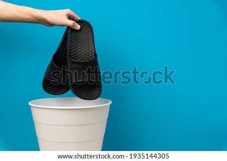 The slipper is thrown into the trash for disposal and recycling Royalty-Free Stock Photo #1935144305