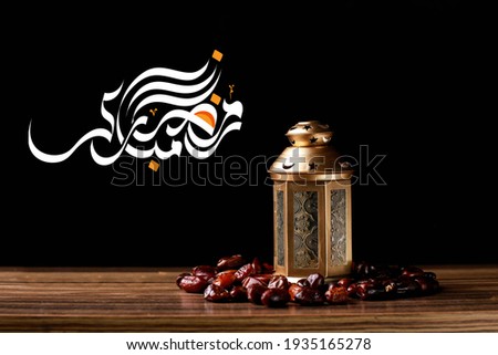 TRANSLATION: RAMADAN MUBARAK written in Arabic calligraphy with Lantern and Dates on White isolated background. Ramadan Mubarak holiday celebration concept. Ramadan Mubarak Written in Arabic. Royalty-Free Stock Photo #1935165278