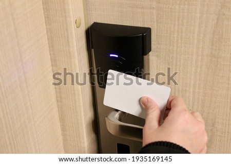 Proximity key card to authenticate for unlock door. Hand holding key card.Key card Hotel room access