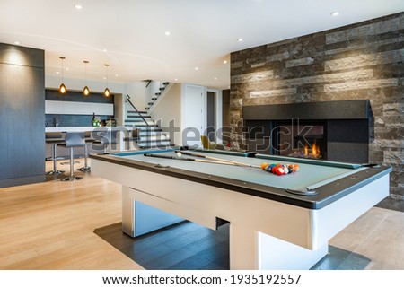 Relaxing with colourful chairs, pool table, fireplace, tv and bar Royalty-Free Stock Photo #1935192557