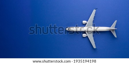 Top view of white commercial passenger airline airplane jet on blue background with copy space. Transportation tourism travel aviation and business concept. Royalty-Free Stock Photo #1935194198