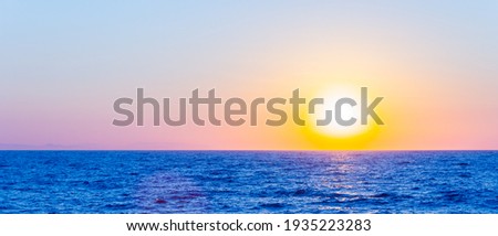 Orange sunset over sea. Bright sun over the sea horizon