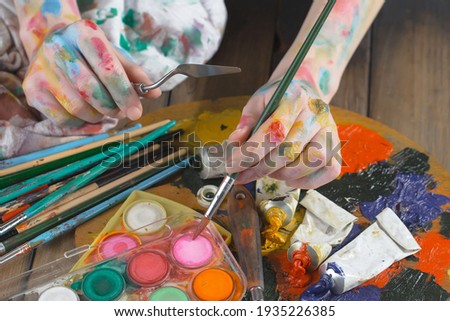 Woman's hand with paint brush.