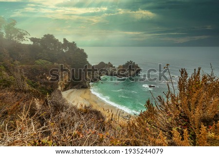 McWay Falls in Big Sur, a beautiful landscape, on the Pacific coast of California, light fog. Concept picture for postcards, tourist guide and travel guide.