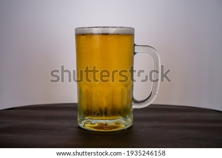 beer chopp on a brown leather like surface and a white background