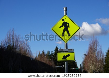 Pedestrian crossing traffic sign on the street with a Blue sky background.