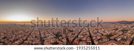 Panoramic aerial drone shot of Barcelona city skyline with church before sunrise in winter