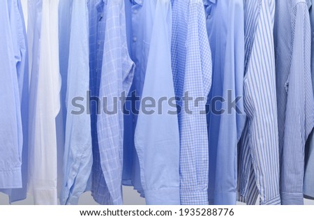Set of Men's striped long sleeved blue shirt close up on hanger ,shirt background
