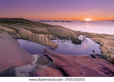 Sunset on skerries in Ytre Hvaler National Park, on the island of Kirkeoy in Norway Royalty-Free Stock Photo #1935310255