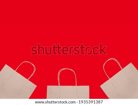 Banner. Three White shopping bags isolated on red background. Advertising, shop sales concept. Top view. Copy space for text.   