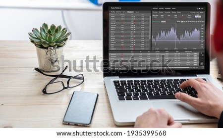 Trade platform, forex trading. Stock exchange market analysis, Man working with a laptop, monitoring app on screen, office desk background. Binary option, candlestick chart. Royalty-Free Stock Photo #1935399568