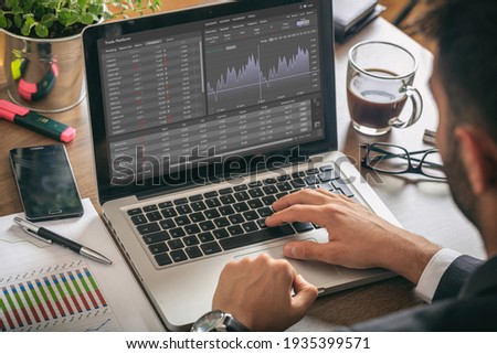 Trade platform, forex trading. Stock exchange market analysis, Man working with a laptop, monitoring app on screen, office desk background. Binary option, candlestick chart. Royalty-Free Stock Photo #1935399571