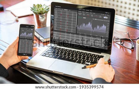 Stock exchange market analysis, Man working with a laptop, monitoring app on screen, office desk background. Trade platform, forex trading. Binary option, candlestick chart. Royalty-Free Stock Photo #1935399574