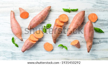 Sweet potatoes on a white wooden background. Dietary food. Top view. Free space for your text.