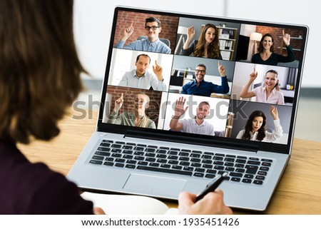 Video Conferencing Call Waving Hello With Hand Royalty-Free Stock Photo #1935451426
