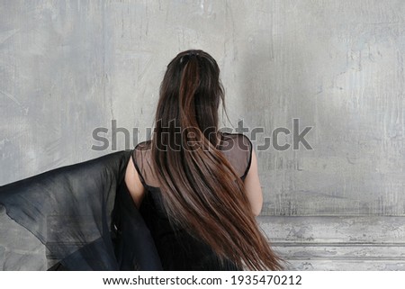 Woman dancer backside in motion with a cloth against the wall