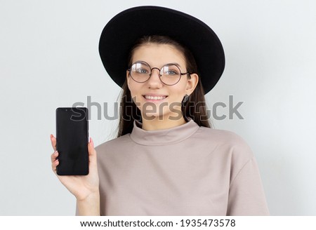 Portrait of a happy casual woman showing blank smartphone screen isolated on a white background