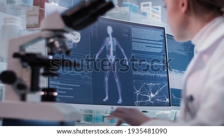 Female doctor working in laboratory. Studying human skeleton and DNA samples Royalty-Free Stock Photo #1935481090