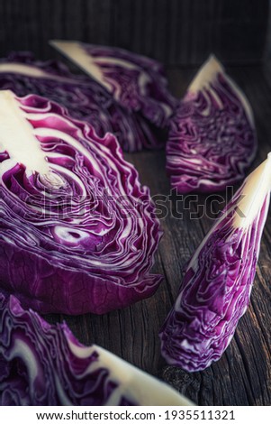 Half and sliced fresh red cabbage on wooden rustic table.