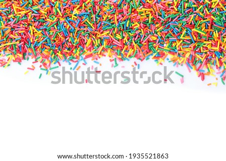 Colorful sprinkles on white background, top view. Confectionery decor Royalty-Free Stock Photo #1935521863