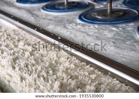 carpet washing machine with round brushes in operation, blurred objects, with a shallow depth of field, bokeh, and blurred background and foreground