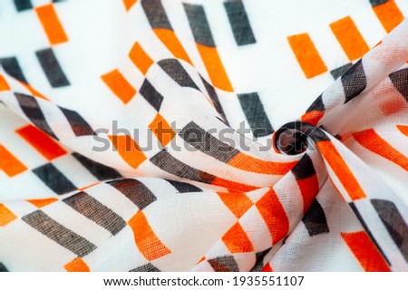 White silk fabric with red and black geometric rhombus shapes. abstract illustration pink-orange franc, close-up, background for design, vintage bright pattern. Texture. Background. Template.