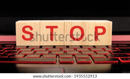 wooden cubes on the keyboard with the word STOP.
