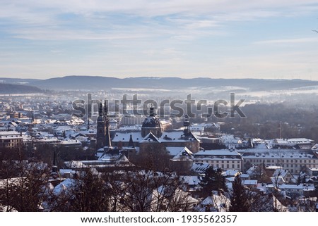 View of snow-covered Fulda with sights like Fulda Cathedral and Fulda Castle from Frauenberg Monastery 