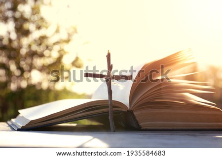 Holy Bible on the background of the Christian cross and the life-giving divine light. The hope of mankind for salvation. The way to God through prayer. The Resurrection and Rapture of Jesus. Royalty-Free Stock Photo #1935584683