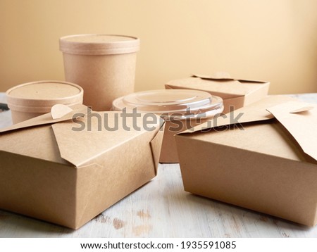 paper containers for takeaway food, isolated on a wooden table Royalty-Free Stock Photo #1935591085