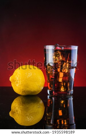 Close-up of fresh drink and lemon  over  a dark red background.