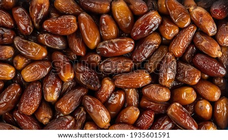 The surface texture of selected dried dates. Natural oriental sweets. Royalty-Free Stock Photo #1935601591