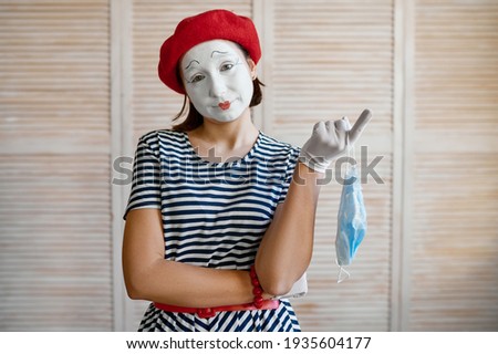 Female mime artist with medical mask