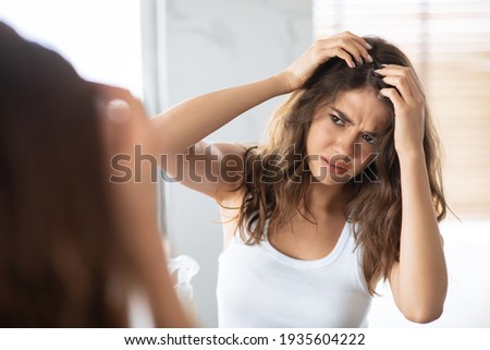 Unhappy Woman Looking At Hair Flakes Having Dandruff Problem Indoor