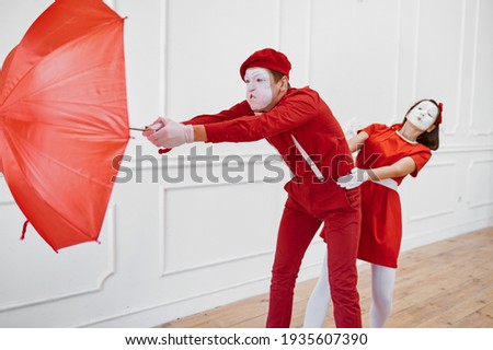 Mime artists, scene with umbrella in windy weather